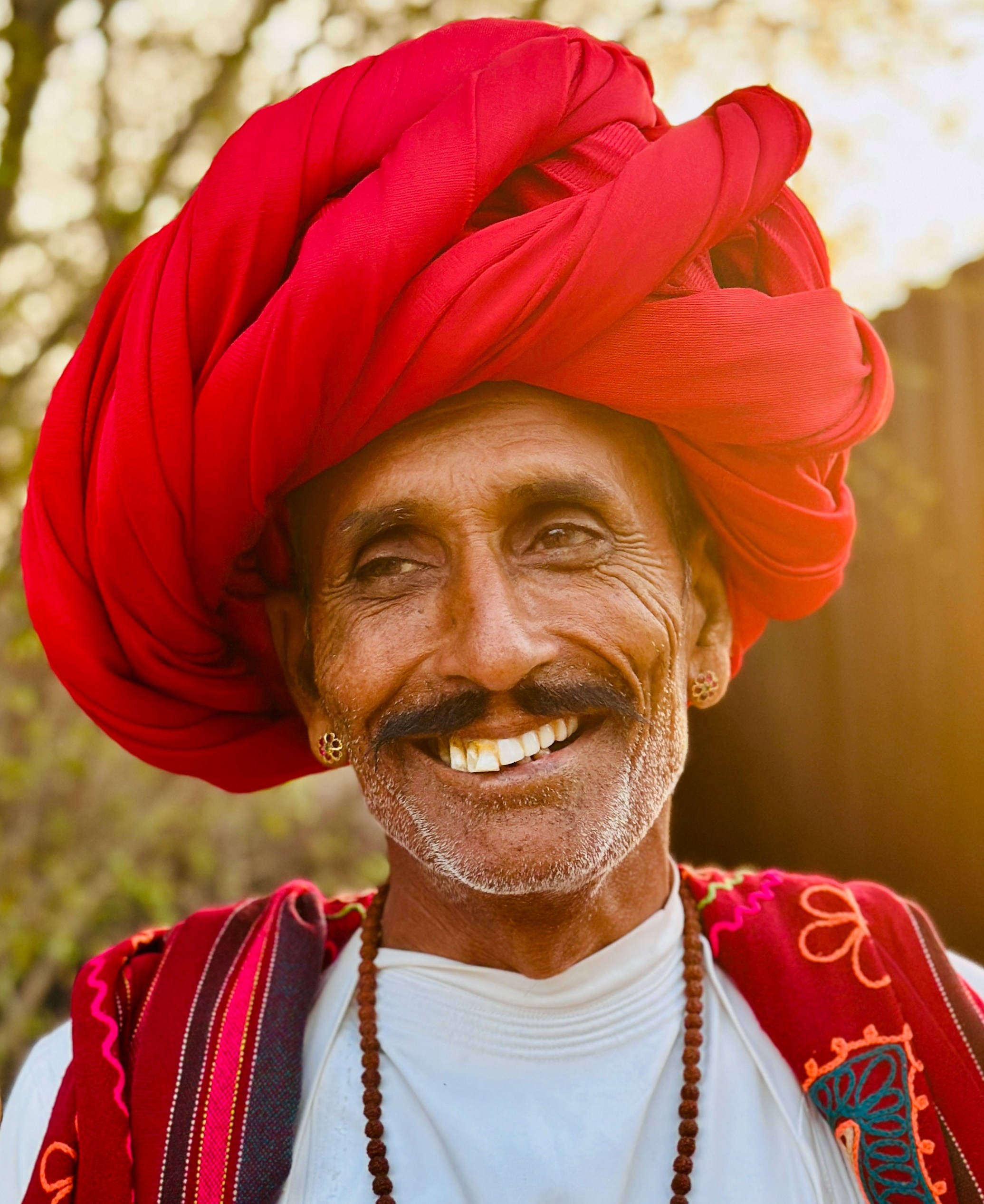 A smiling man with an enormous red turban.
